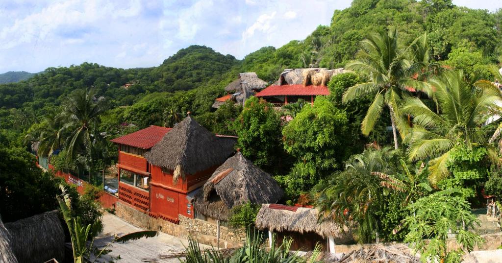 un complejo en una colina con árboles y montañas en Villa Escondida en Zipolite