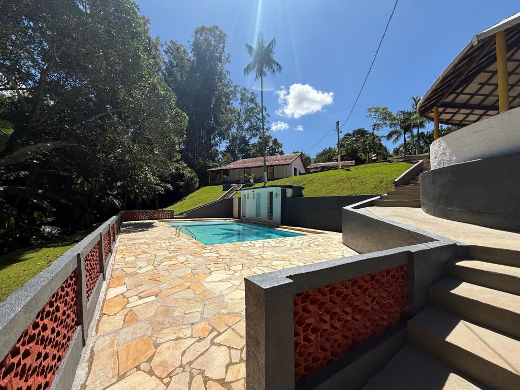 a backyard with a swimming pool and a house at Vale Verde in Jacutinga