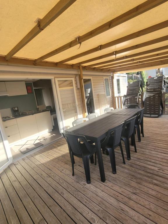 a wooden deck with a table and chairs on it at Mobil-home MJ in Seignosse