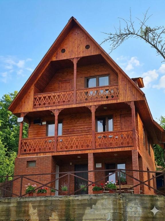 a large wooden house with a balcony at Wooden Cottage '' Lailashi '' in Surmushi