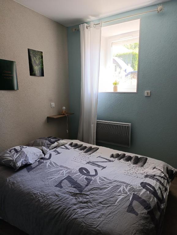 a bedroom with a bed with a painting on it at chez MAG et YANN in La Séauve-sur-Semène