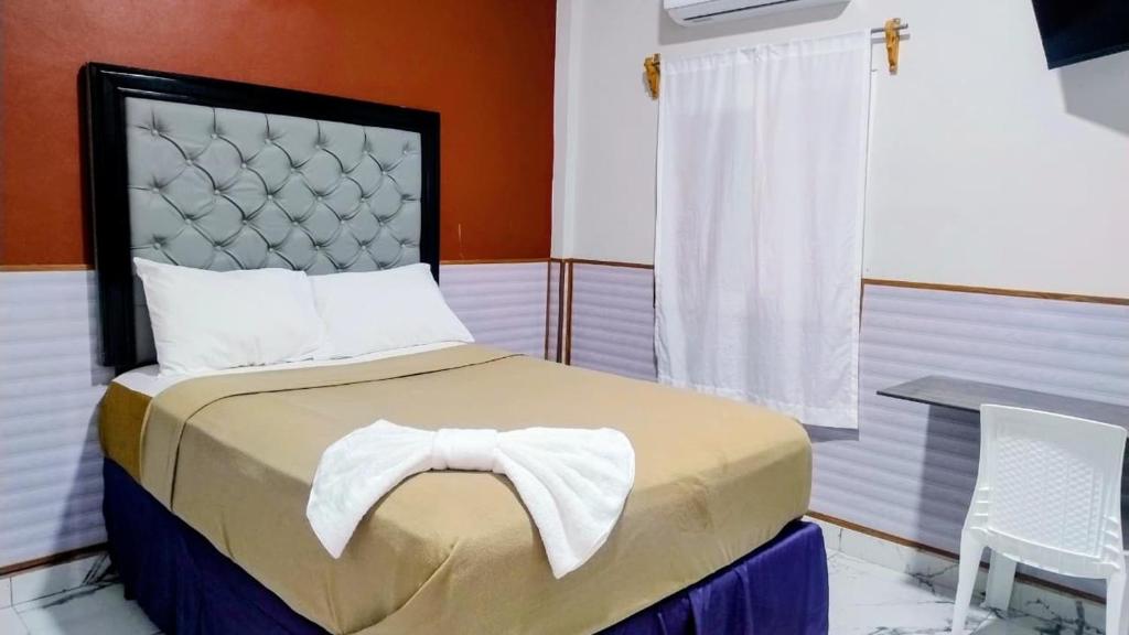a bedroom with a bed and a table and a window at Hotel Urban Center RM in San Marcos