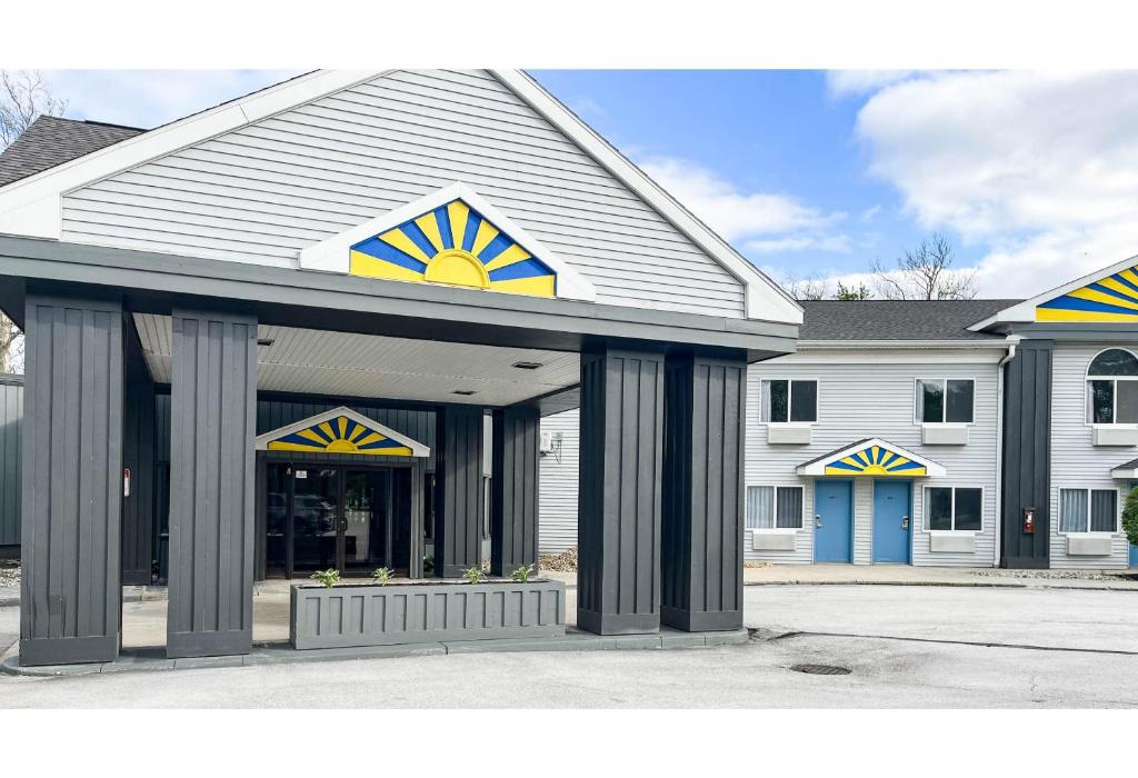 a large white building with blue and yellow accents at Studio 6 Suites - Tiffin, OH in Tiffin
