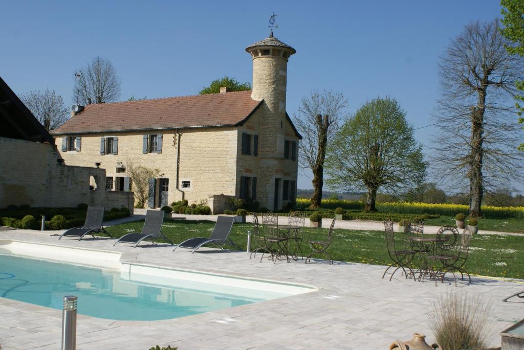a pool in front of a building with a lighthouse at chambres d hotes ochene in Daix