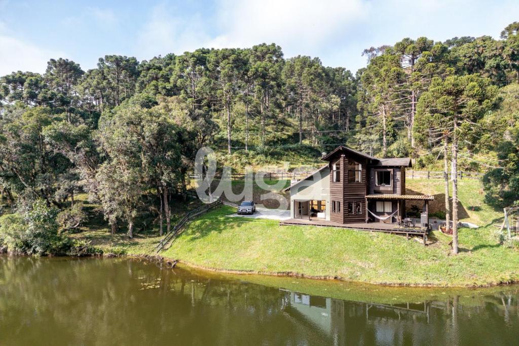 an image of a cabin on a hill next to a lake at Faxinal das Águas Retreat - 5min from downtown in Rancho Queimado
