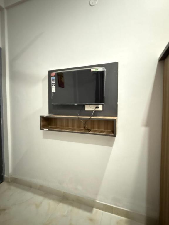 a tv on a wall in a white wall at Amrit bela in Haridwār