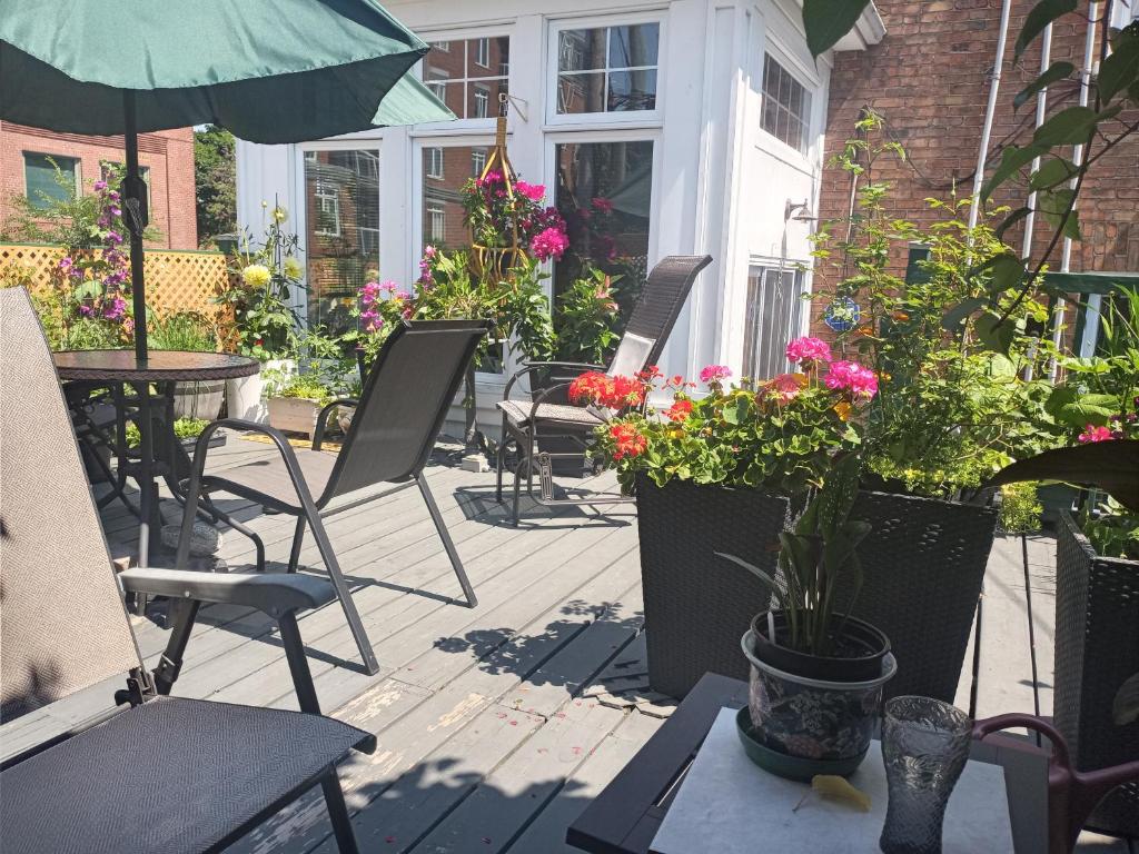a patio with chairs and tables and flowers at B&B Le Transit in Quebec City