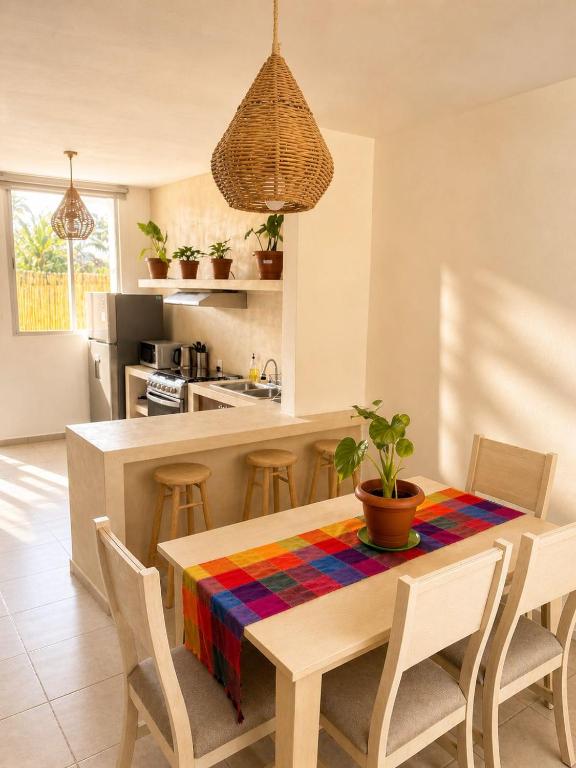 a kitchen with a wooden table with chairs and a dining room at Casa Coral in Puerto Morelos