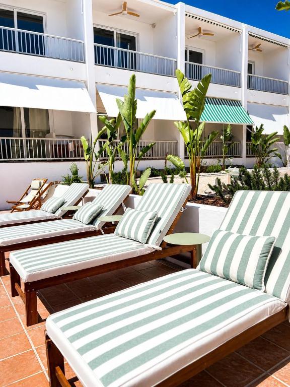 a row of chaise lounges on a patio at Hotel S'Algaret in Fornells