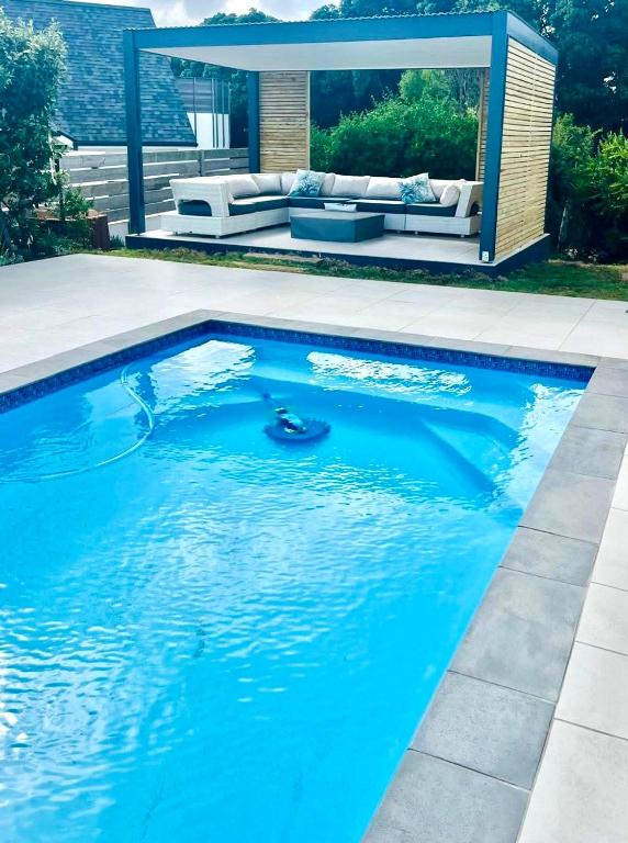 a swimming pool with a couch in the background at Frank Road At The beach in St Francis Bay