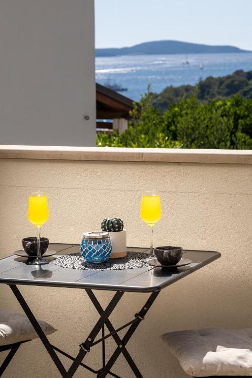a table with two glasses of orange juice on a balcony at Jakov & Antonia Heritage Estate in Hvar