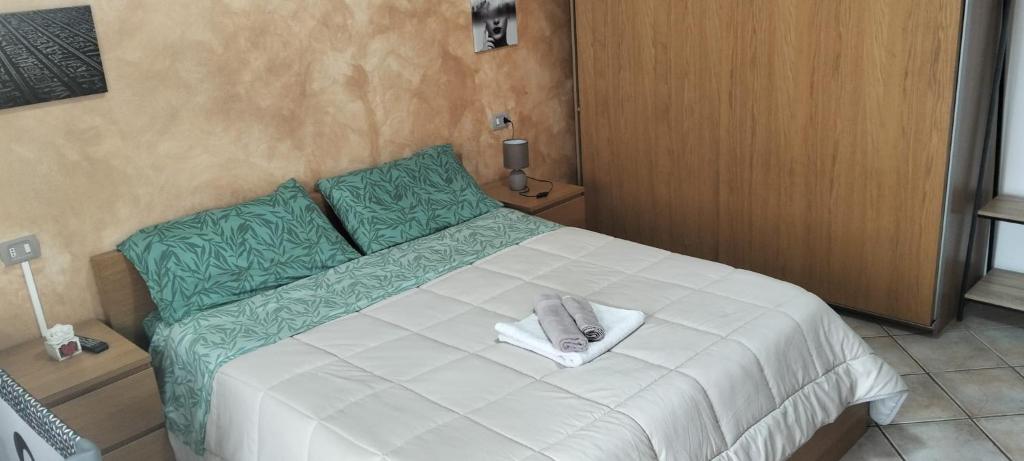 a bedroom with a white bed with a towel on it at Adda House in Trezzo sullʼAdda