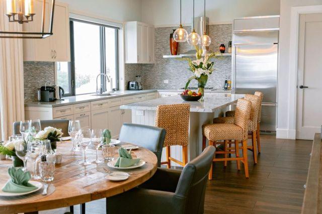 a kitchen with a wooden table with chairs and a dining room at The Loren at Pink Beach in Tuckerʼs Town
