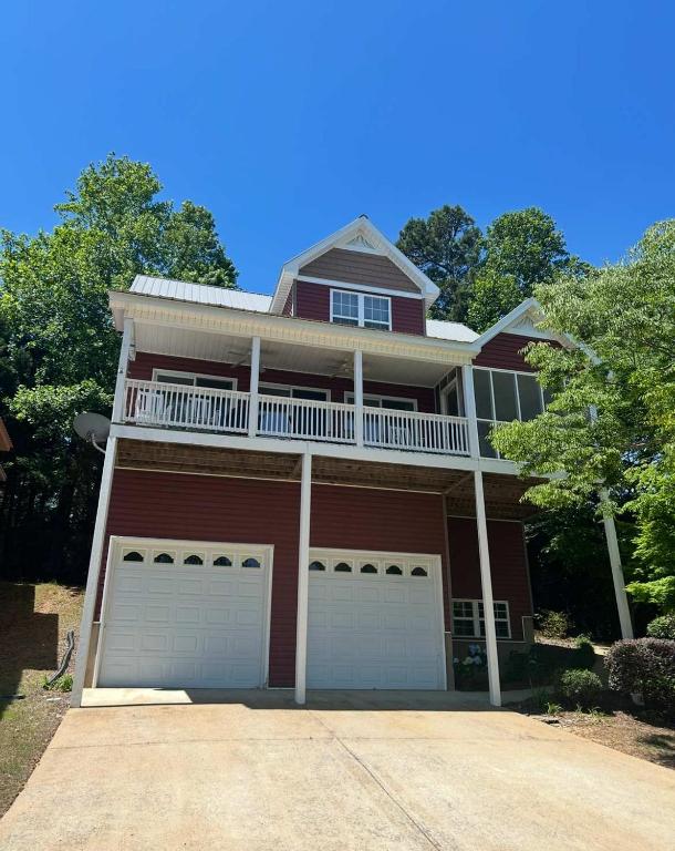 a red brick house with a balcony and two garage doors at High Cotton in Leesburg