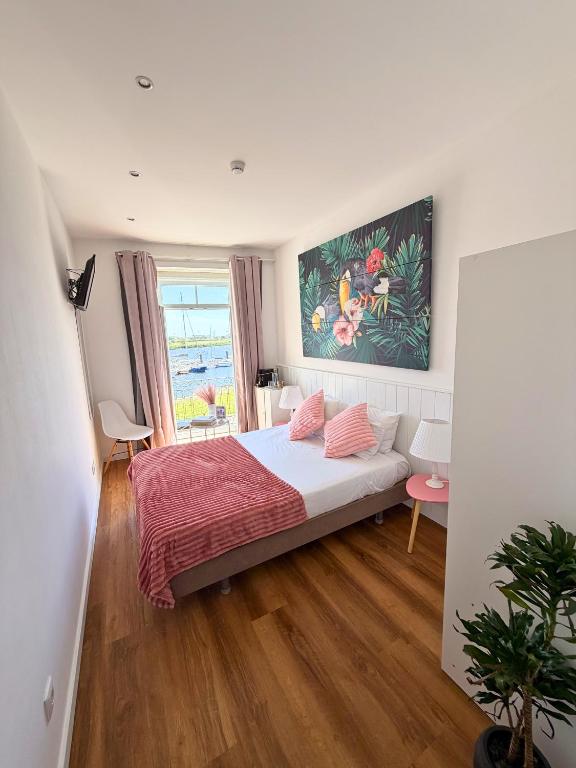 a bedroom with a bed and a painting on the wall at Naval Guest House in Vila do Conde