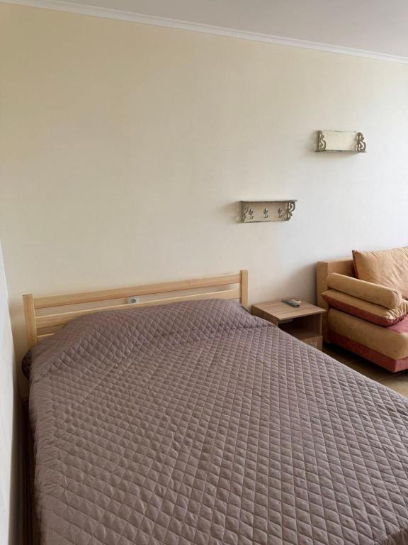 a bedroom with a bed and a chair at Promenad San in Dobrovelychkivka