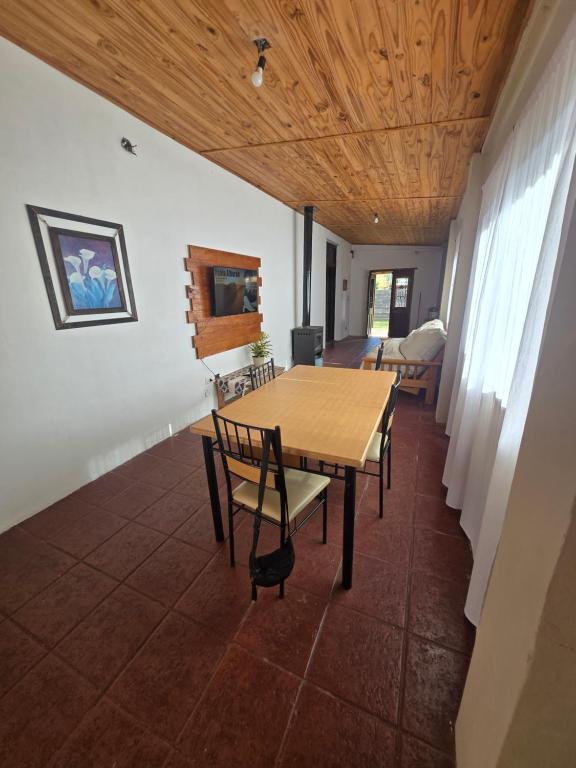 a dining room with a wooden table and chairs at El descanso in Veronica