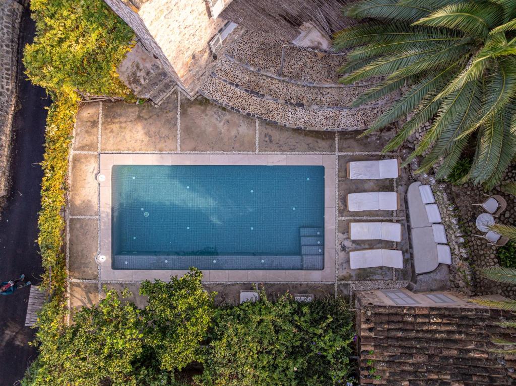 an overhead view of a swimming pool with white chairs at Can 'Jeson in Deia