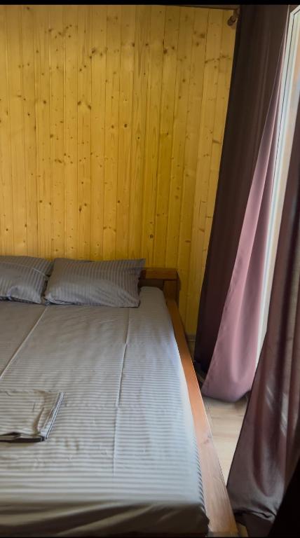 a bed sitting in a room with a curtain at Shulgivka in Shulʼgovka