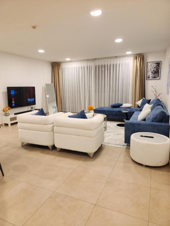 a living room with two couches and a tv at Premium 2 Bedroom Apartment Near Airport in Muscat