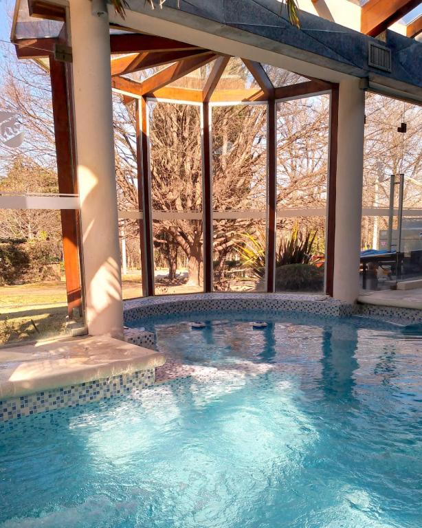 a swimming pool in front of a building with windows at Berna Hotel & Spa in Villa General Belgrano