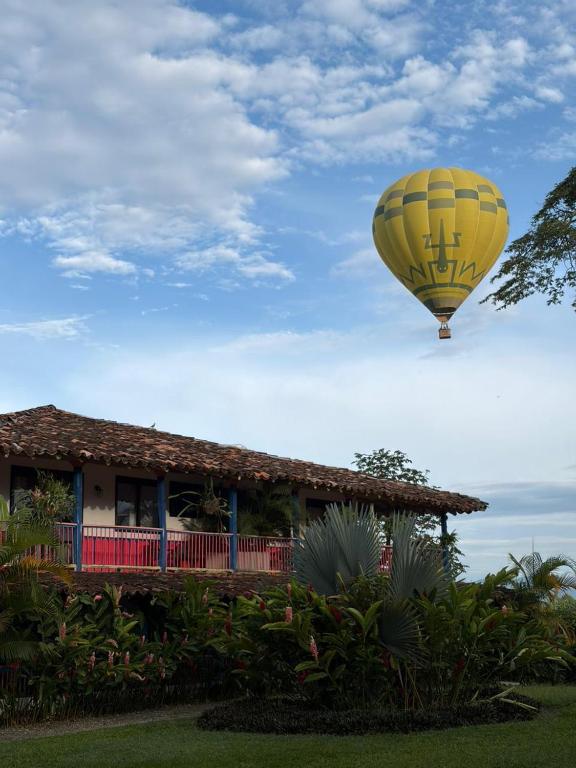 a yellow hot air balloon flying over a house at El Percal Hacienda Hotel in Montenegro