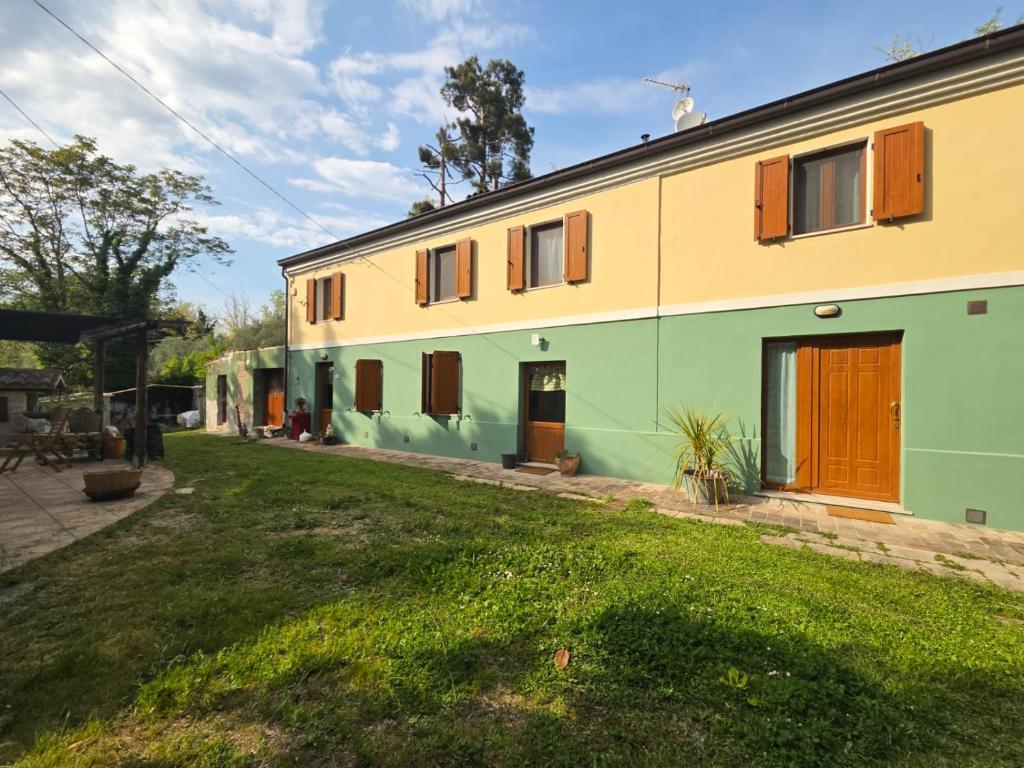 a house with green and yellow walls and a yard at Locazione del cavaliere in Fano