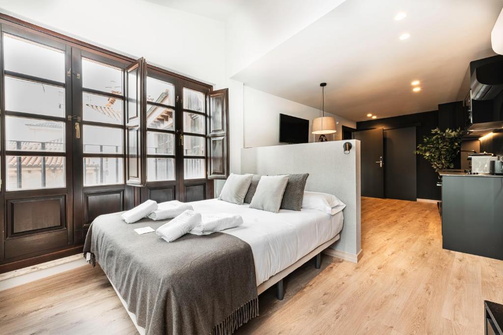 a bedroom with a large bed with white pillows at Ando Apartments Boutique in Salamanca