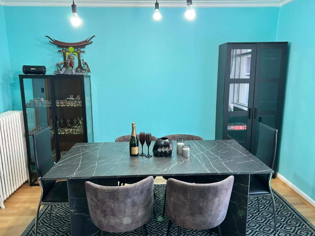 a dining room with a table with chairs and a blue wall at Chic Townhouse - Views Telescope Balcony BBQ in Siglufjörður