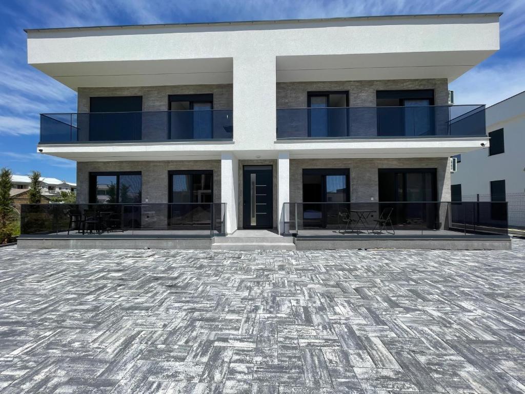 a house with a large patio in front of it at Raba Apartments in Donji Štoj