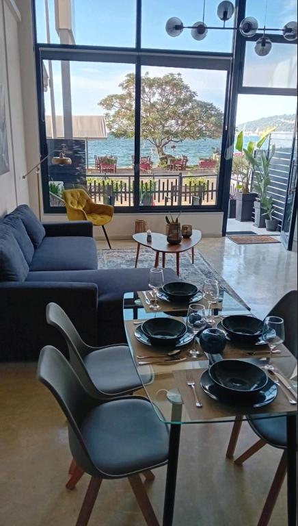a living room with a glass table and a couch at Loft by the sea in Amfilochia