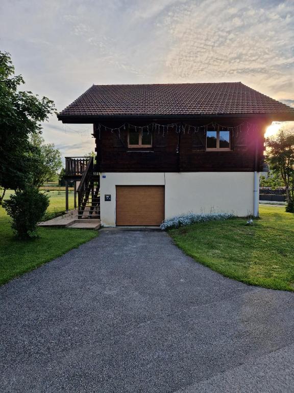 a house with a garage and a driveway at O'Doubs Chalet in La Chaux Neuve