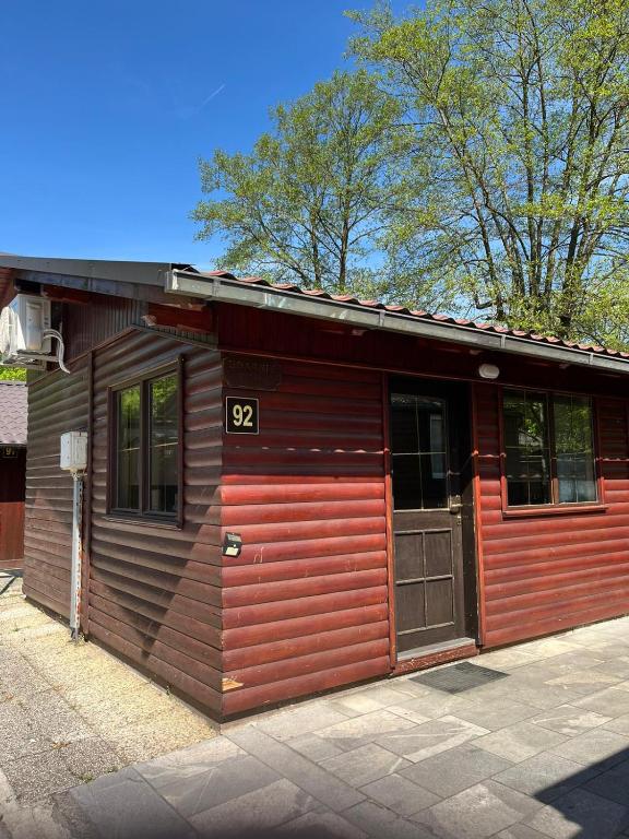 a wooden cabin with the number on it at Cottage house 92 Auqaluna in Podčetrtek
