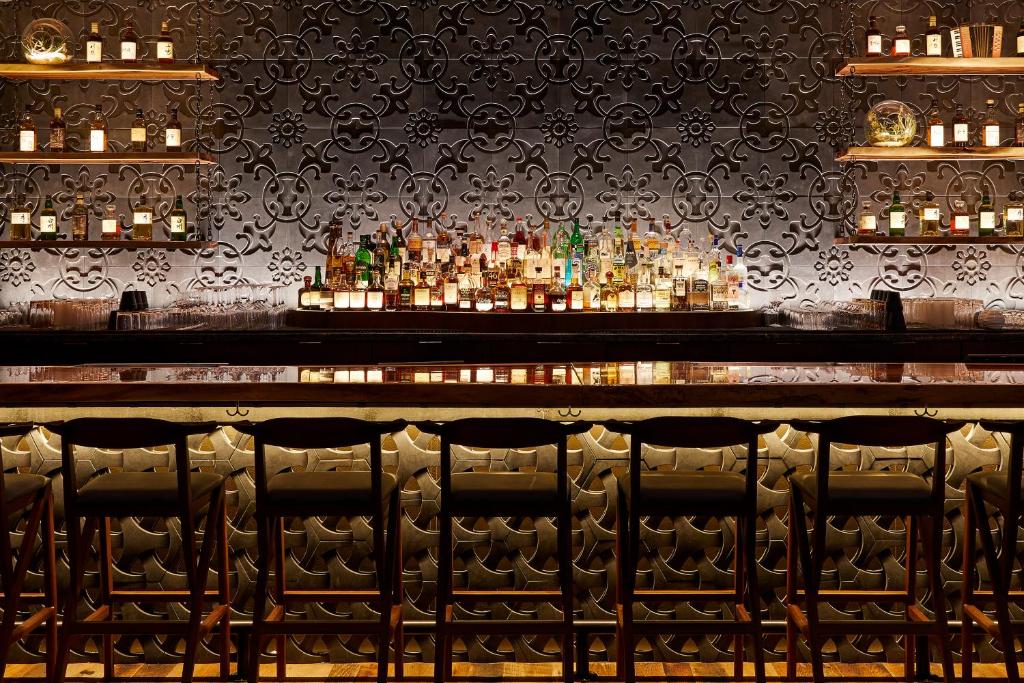 a bar with a bunch of bottles of alcohol at The Godfrey Hotel Boston in Boston
