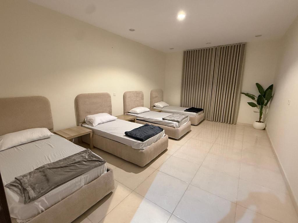 a room with three beds and a couch at استديو كلاود غرفتين نوم in Al Baha