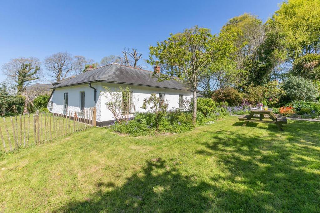 a white house with a picnic table in a yard at 3 Bed in Lostwithiel oc-cwhite in Saint Winnow