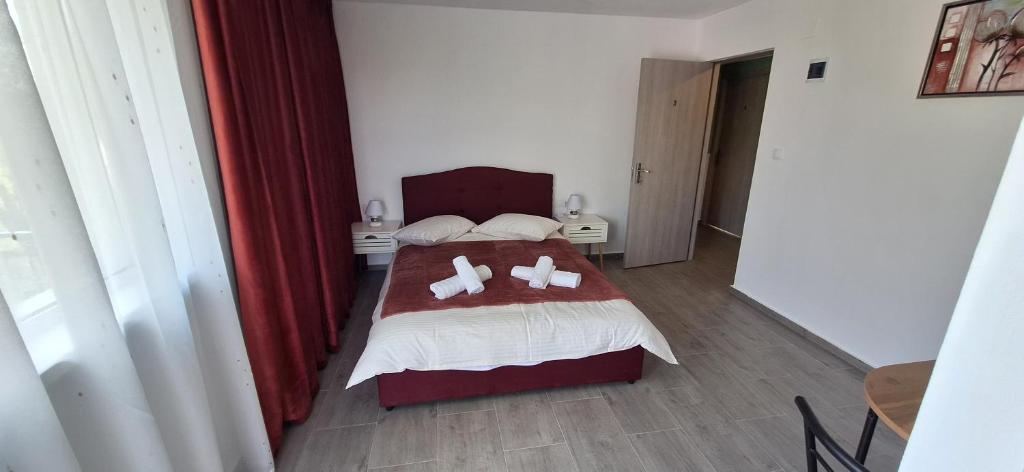 a bedroom with a bed with two slippers on it at Vila Armonia in Curtea de Argeş