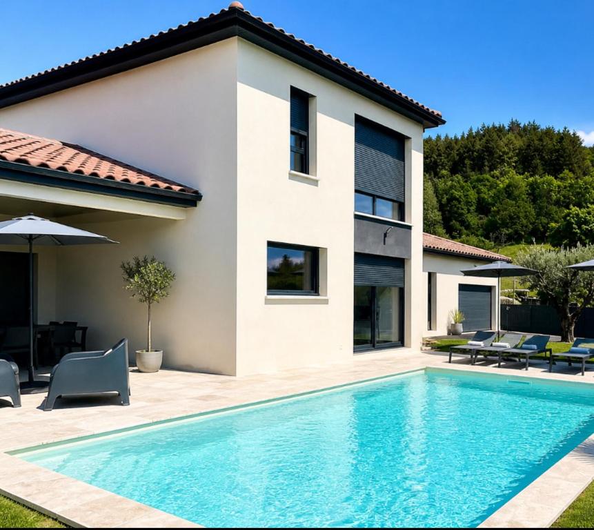 a swimming pool in front of a house at Villa avec piscine chauffée in Ancy