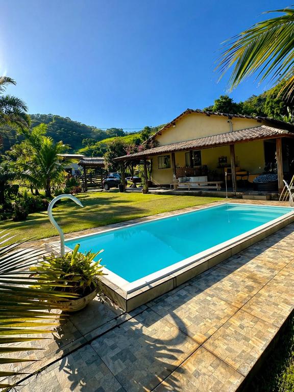 a swimming pool in front of a house at Casa na Serra Canto do Jair in Casimiro de Abreu