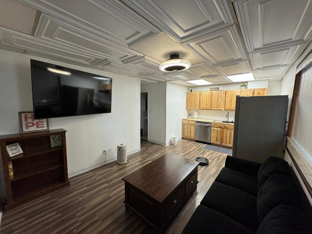 a living room with a couch and a flat screen tv at Anchorage Fireoved Experience in Anchorage