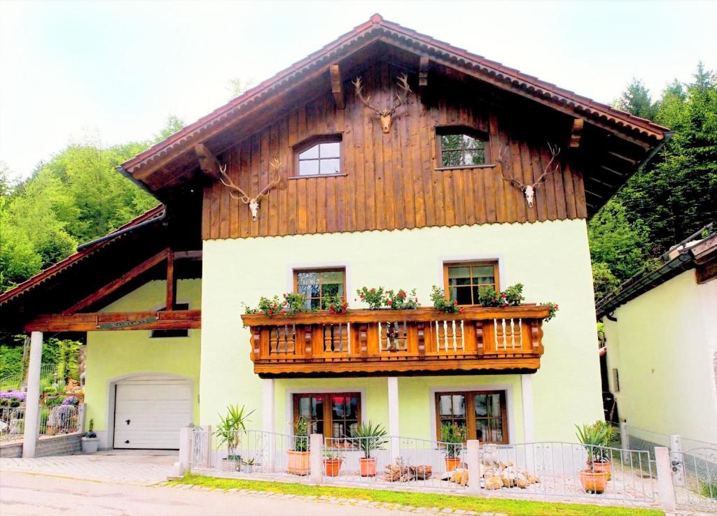 a house with a wooden balcony on top of it at Ruhige Oase mit Pool & Garten Ferienwohnung Niggl in Untergriesbach