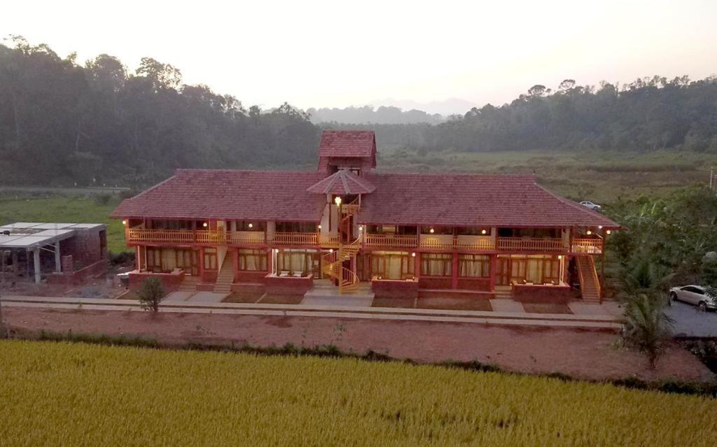 a large wooden house in a field at HighFields Coorg in Virajpet