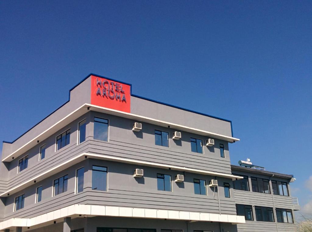 a building with a red sign on top of it at Hotel Aroha in Tagaytay