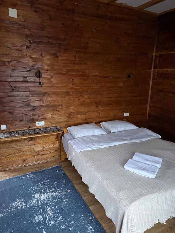 two beds in a room with wooden walls at Panorama Gomarduli in Shuakhevi