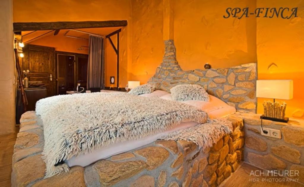 a bedroom with a large bed in a stone wall at Ferienhaus-Sauna Pool Whirlpool in Grimma