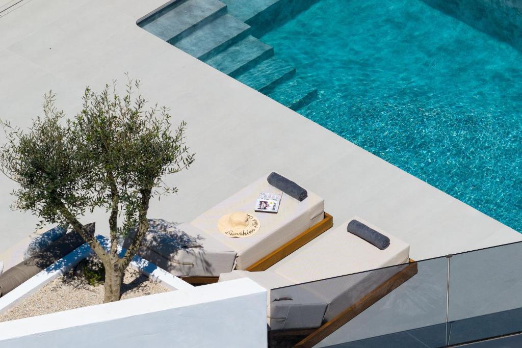 a pool with a table and a tree next to it at Ortus Luxury Residence in Rhodes Town
