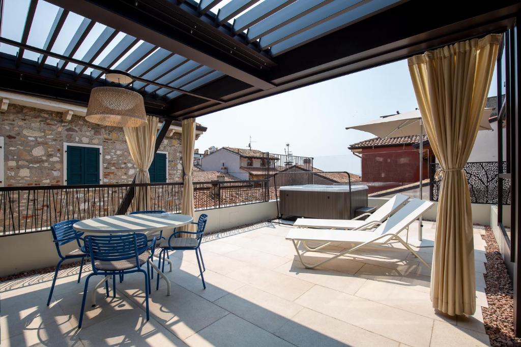 a patio with a table and chairs on a balcony at Calle Suite Lazise in Lazise