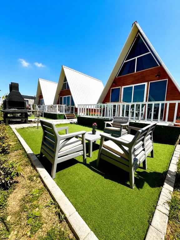 a patio with two chairs and a table and a house at Loft karpasia in Rizokarpaso