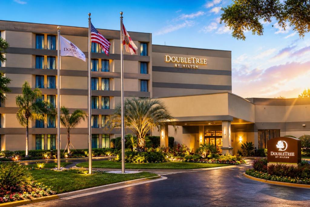 a rendering of the doorman hotel at dusk at DoubleTree by Hilton Orlando East - UCF Area in Orlando