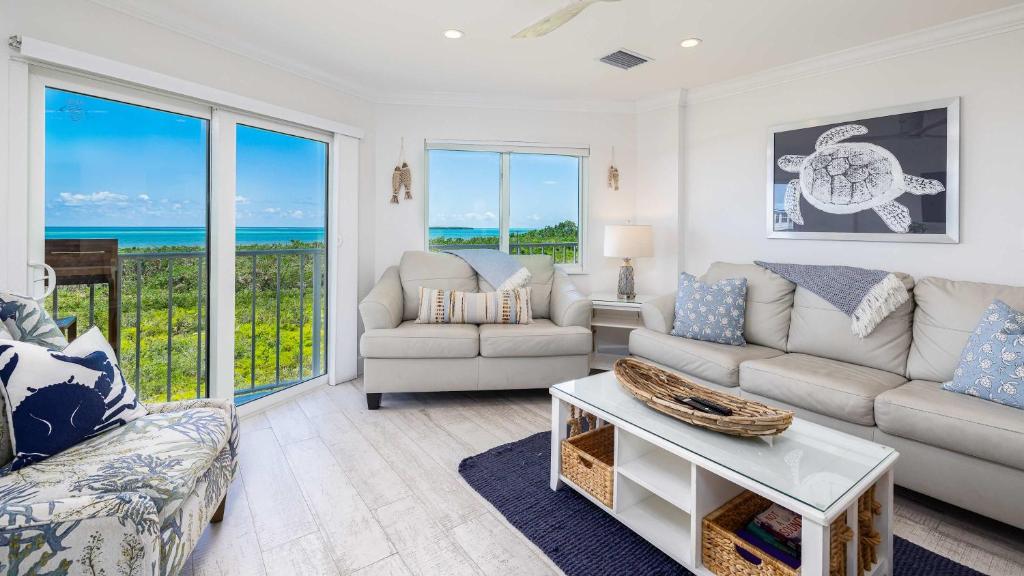 a living room with a couch and a table at Sunrise Oasis - Top Floor Ocean Pointe 2411 in Key Largo